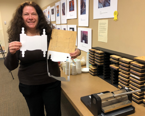 A local teacher in the CCJE Room holding a Torah outline made from the di-cut machine