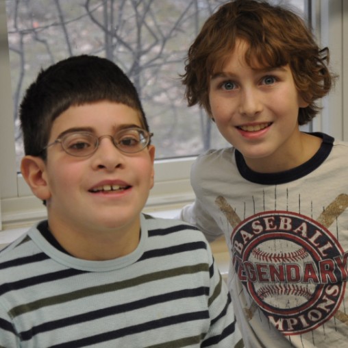 A young boy with special needs and his friend smiling