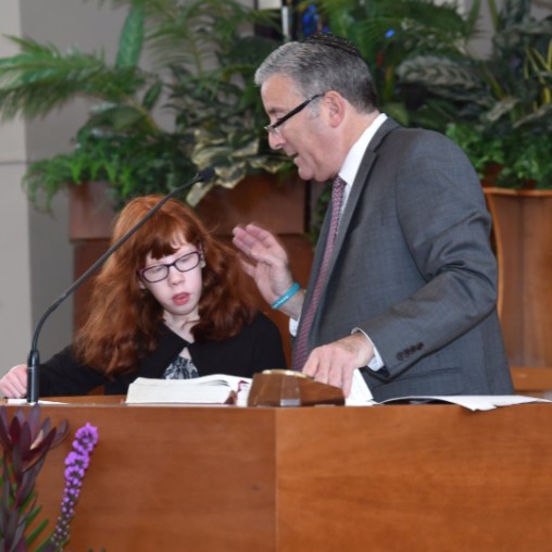 Rabbi Scott Shpeen at the bimah with a young girl with special needs
