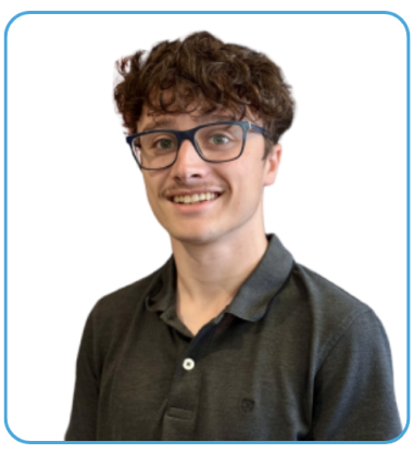 A young man with curly hair and glasses smiling, wearing a dark polo shirt, against a plain background.