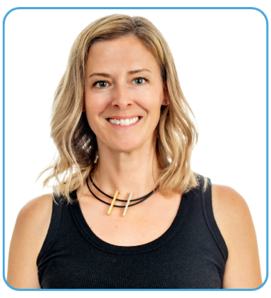 A woman with shoulder-length blonde hair wearing a black tank top and a layered necklace with two wooden pieces, smiling against a plain black background.