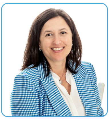 A woman with shoulder-length brown hair smiles while wearing a blue and white checked blazer over a white blouse, against a white background.