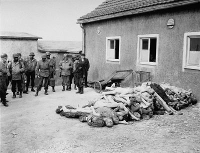 American troops view corpses stacked behind the crematorium